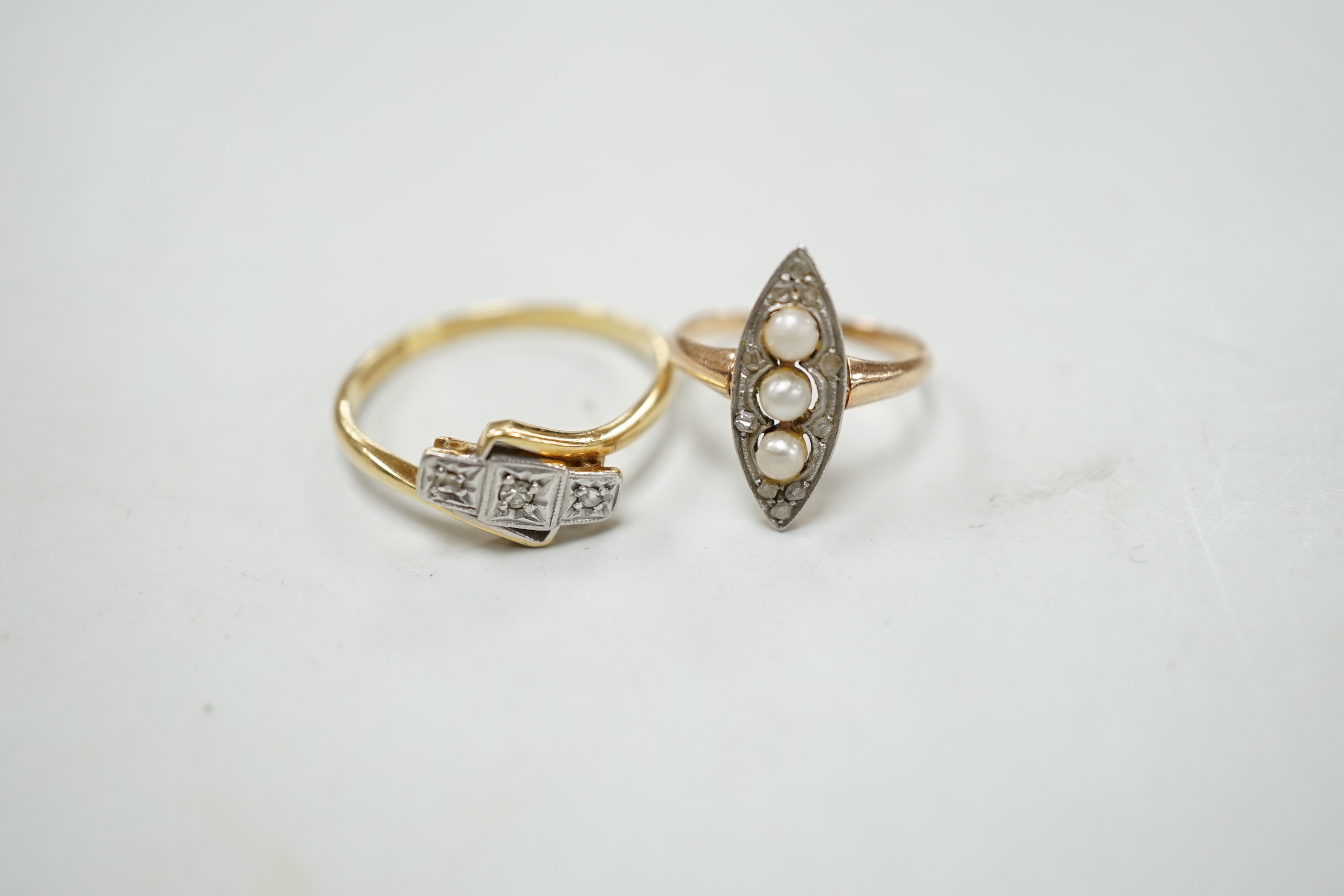 An 18c, pt and illusion set three stone diamond crossover ring, size T, a 585, three stone seed pearl and diamond chip set marquise shaped ring and a Victorian yellow metal and garnet set open work 'belt with buckle' bro